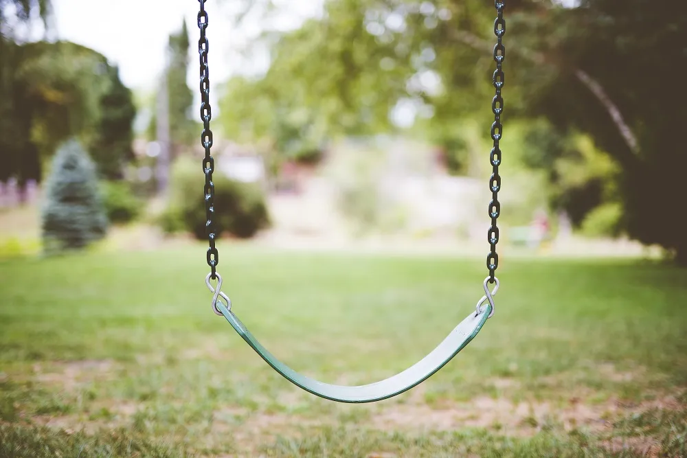 A closeup shot of a swing in a park with a blurred background | Foto: Balanço/Crianças/Abuso | Freepik