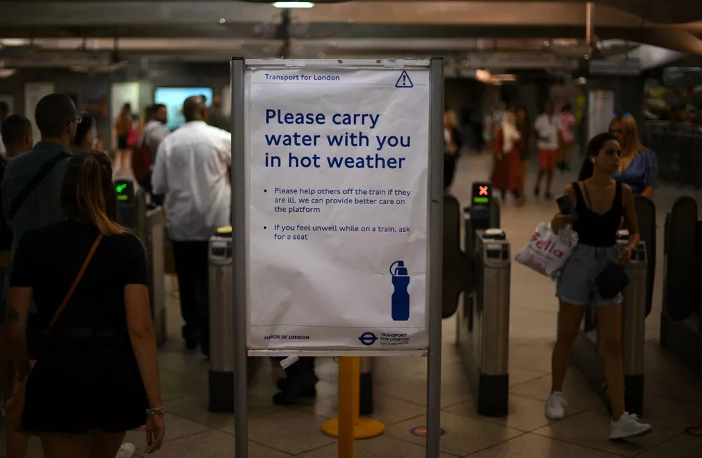 Um cartaz na estação de metrô de Westminster, em Londres, aconselha passageiros a carregar água enquanto viajam durante o período de extremo calor  Foto: Daniel LEAL/AFP