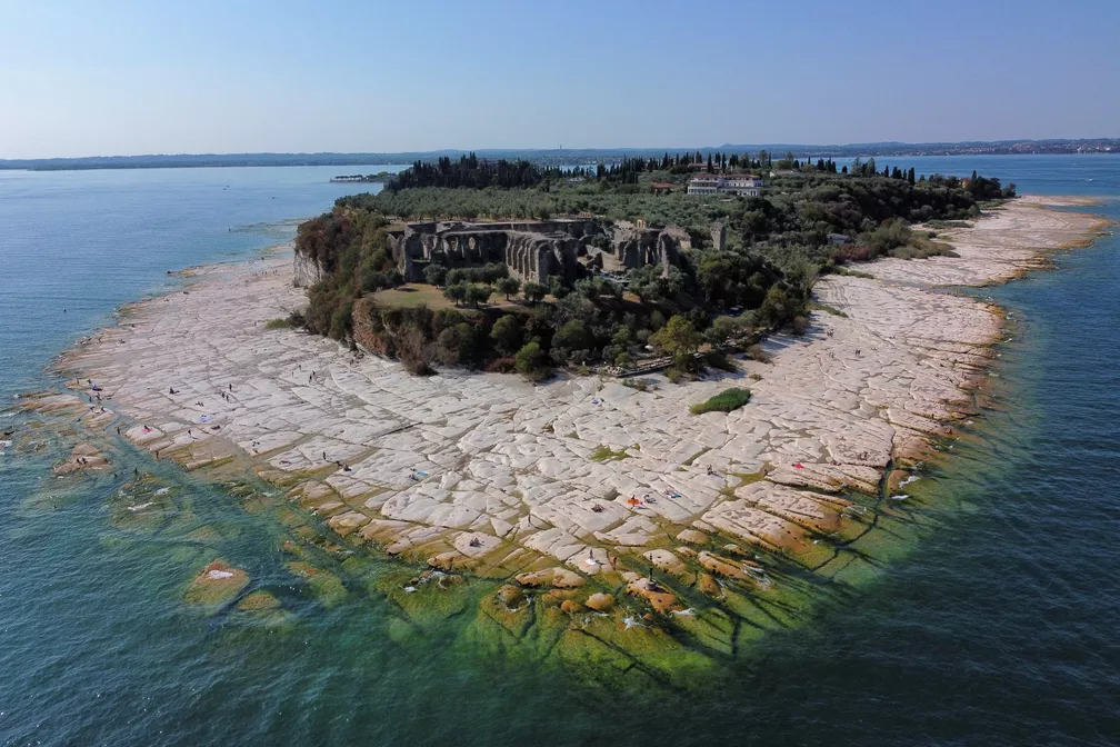 Leito rochoso do lago Garda aparece com a seca e forma uma praia em Sirmione, na Itália ?- Foto: REUTERS/Flavio Lo Scalzo