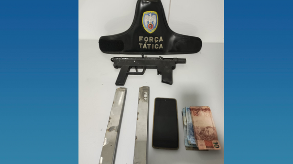 Submetralhadora, carregadores, celular e dinheiros apreendidos dentro de carro. (Polícia Militar/Divulgação)