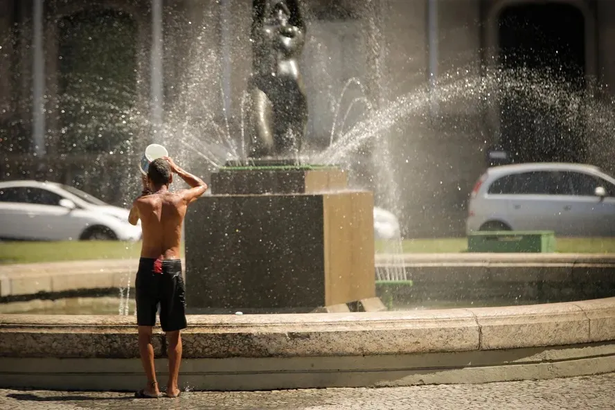 Homem usa água do chafariz para se refrescar no centro do Rio de Janeiro  Foto: Roberto Moreyra/Agência O Globo